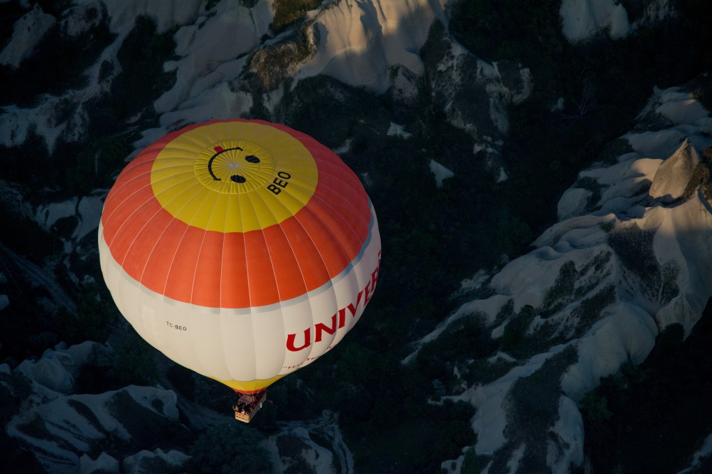 Capturing the breathtaking moment as a hot air balloon takes off into the beautiful skies of Cappadocia, Turkey - a popular and unforgettable attraction for tourists.