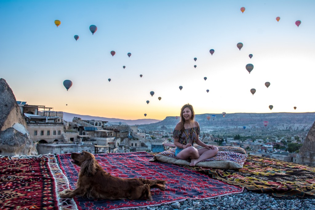 Bianca admiring the hot air balloons soaring above at sunrise in Cappadocia, Turkey - a magical and unforgettable experience for any traveler.