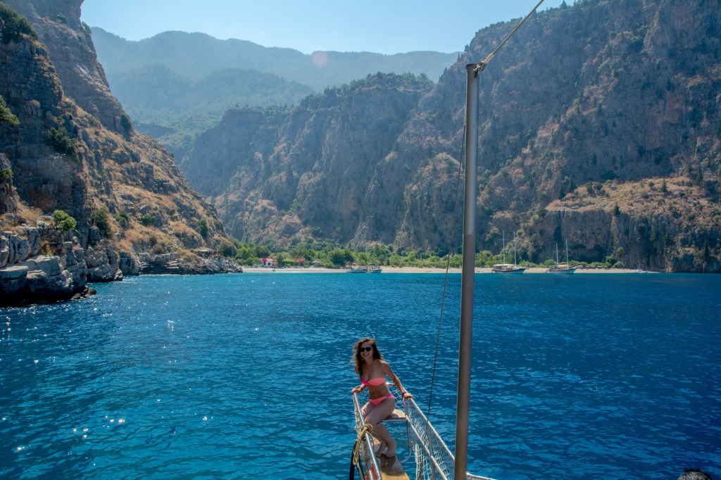 Bianca standing in front of the stunning Ölüdeniz beach in Turkey - a paradise for beach lovers, water sports enthusiasts, and nature seekers.