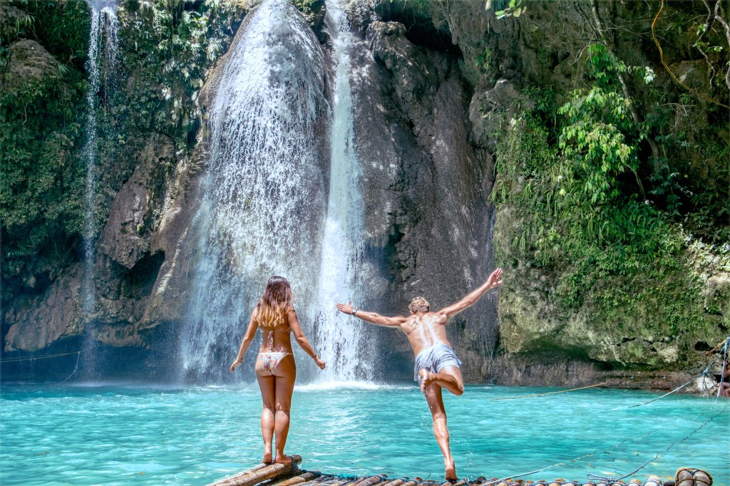 Adventure awaits: Jumping into the crystal clear water at Kawasan Falls, Philippines.