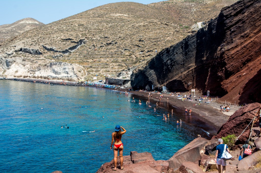 Bianca looking out at Red Beach in Santorini. Discover the best beaches in Santorini with our travel blog.