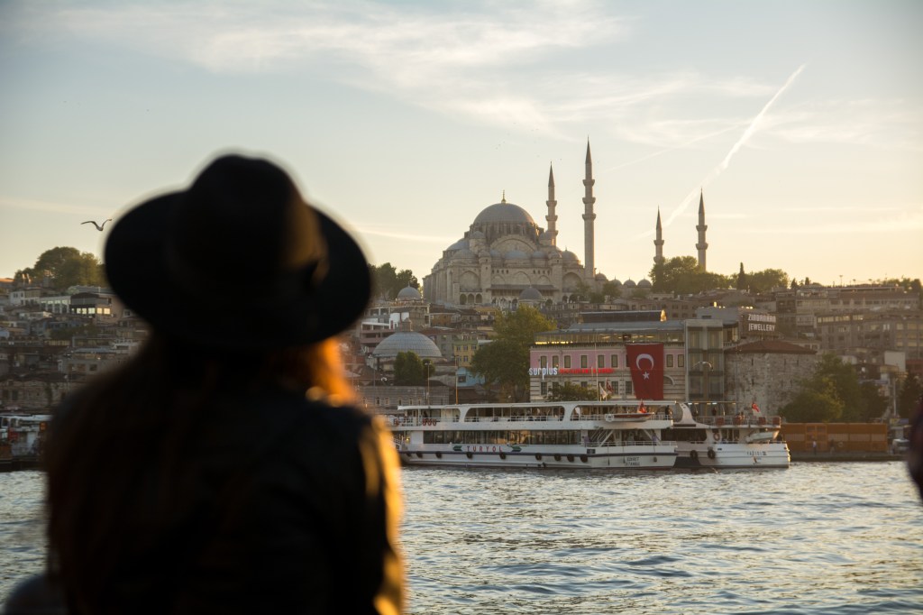 Strolling on the Galata Bridge at sunset - a popular tourist spot in Istanbul, Turkey for capturing stunning photos of the city's skyline and the Golden Horn.