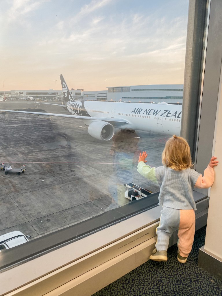 Toddler looking out at a plane.