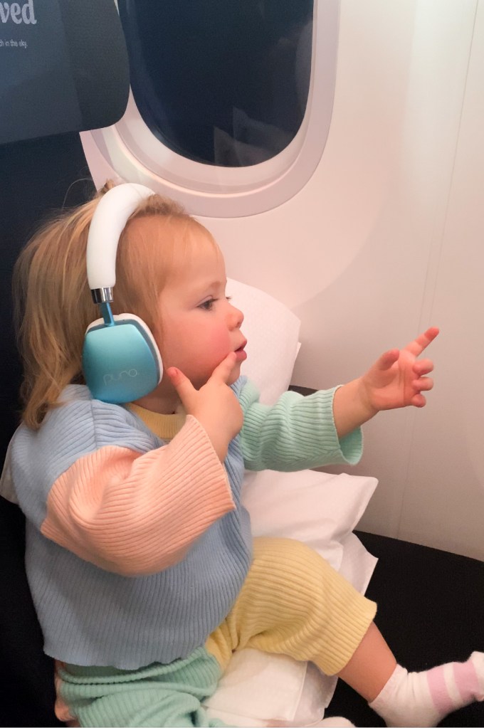 Toddler using Florence enjoying screen time on the plane using her Noise Cancelling Headphones on long haul flight.