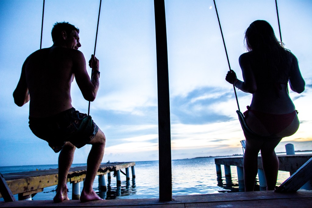 Sunset Serenity - Bianca and Brett Swinging into Bliss at Underwater Vision, Utila Island, Honduras.