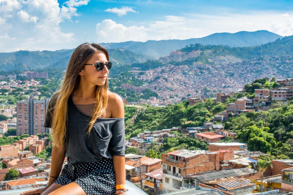 Bianca enjoying a breathtaking view of Medellin from above, with the city's skyline stretching out below her. A stunning travel moment captured high above the bustling streets, showcasing the beauty of Medellin's landscape.