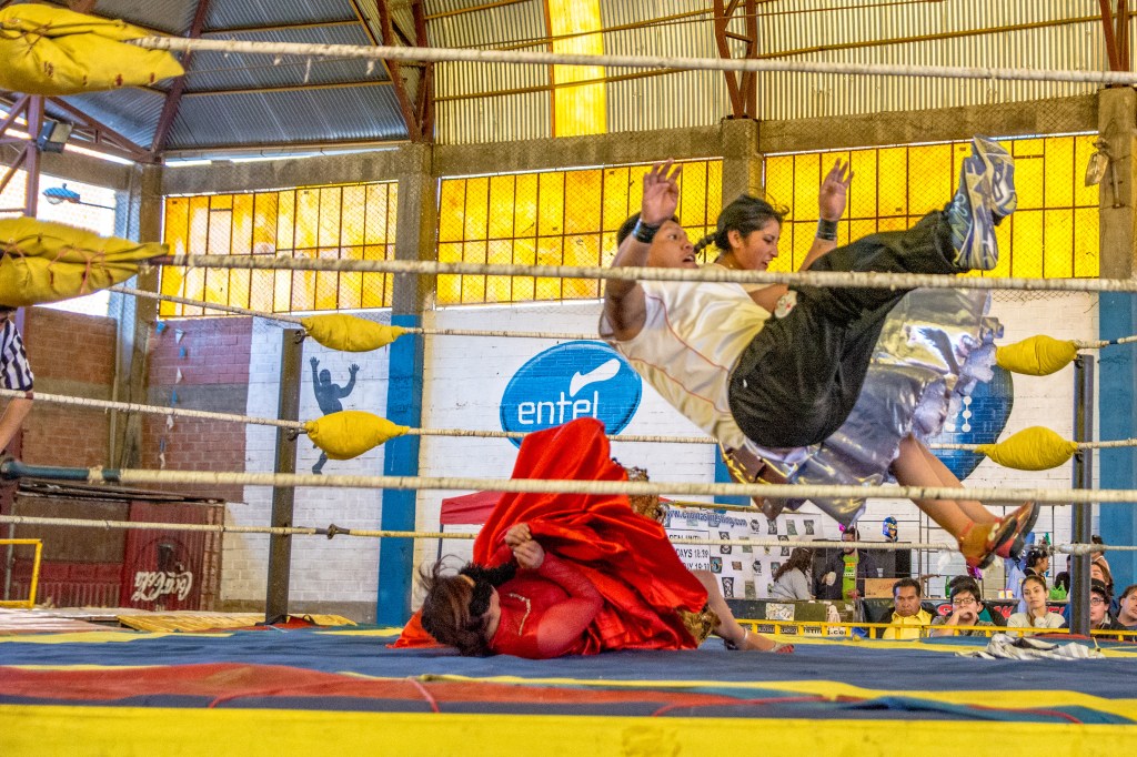 Image showcasing the exhilarating rounds of cholita wrestling in Bolivia, featuring the intense and captivating spectacle of women wrestling in traditional attire, offering a unique cultural experience.