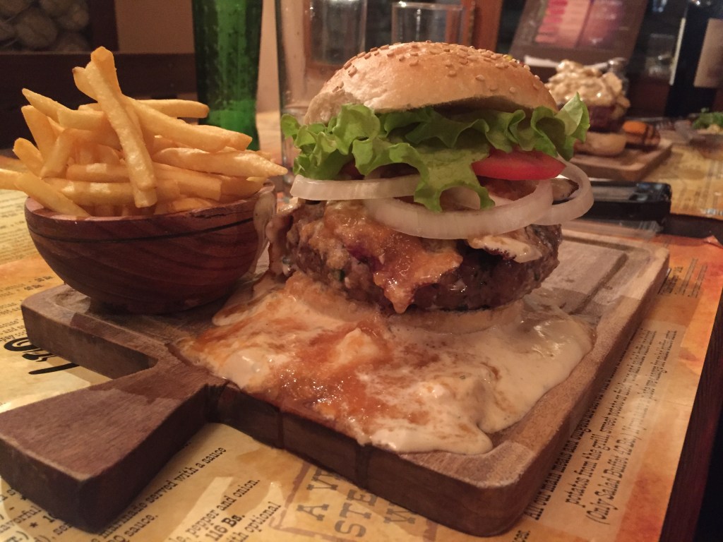 Image capturing the interior of a café adorned with Maori designs, owned by a Kiwi, offering a blend of traditional and western cuisine, providing a comforting and familiar atmosphere for travelers.