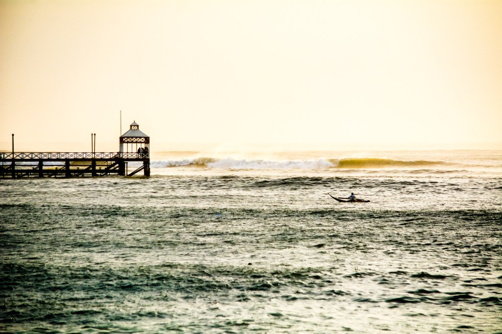 Image capturing the surf scene at Huanchaco, a must-visit spot for surfers, known for left-handed waves along the beach and occasional hidden rights.