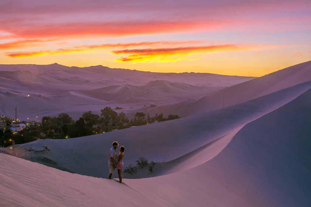 Image capturing a stunning sunrise/sunset moment atop sand dunes, showcasing the breathtaking beauty of early morning or evening hues.