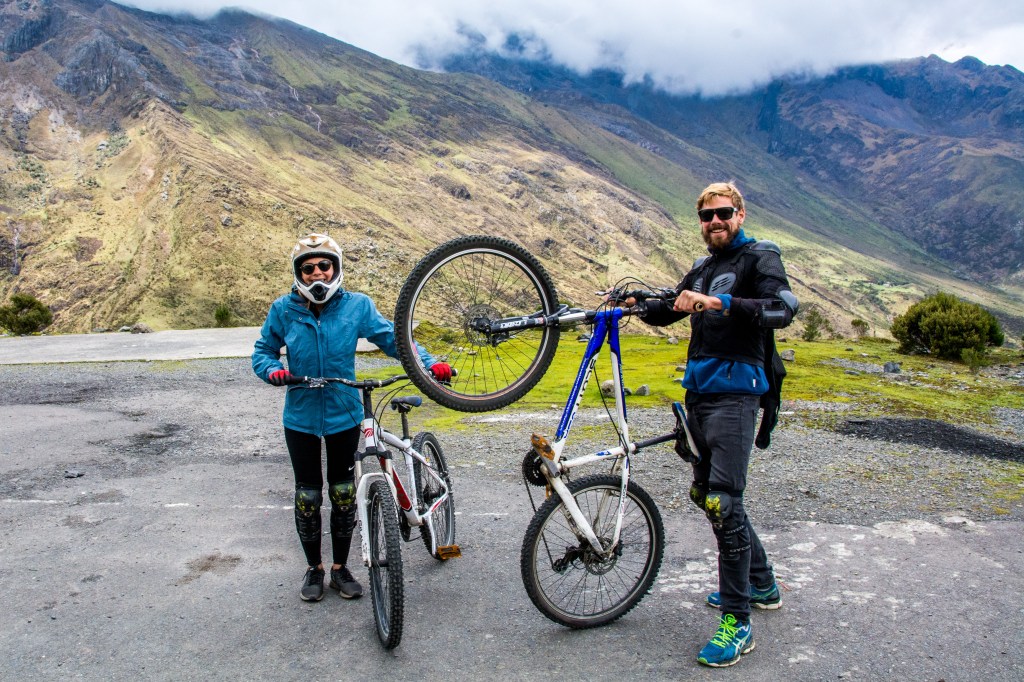 Image capturing adventure enthusiasts B&B cycling down the steep mountains of Peru, showcasing thrilling outdoor activities amidst breathtaking landscapes.