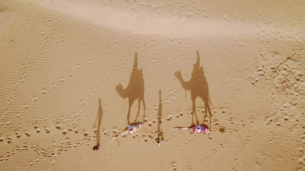 Aerial view: Bianca and Brett riding camels