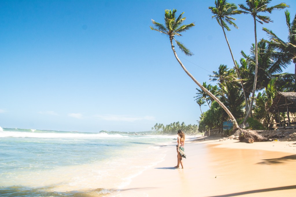 Image capturing admiration of the crystal-clear waters at Dalawella Beach, showcasing its pristine beauty in Sri Lanka.