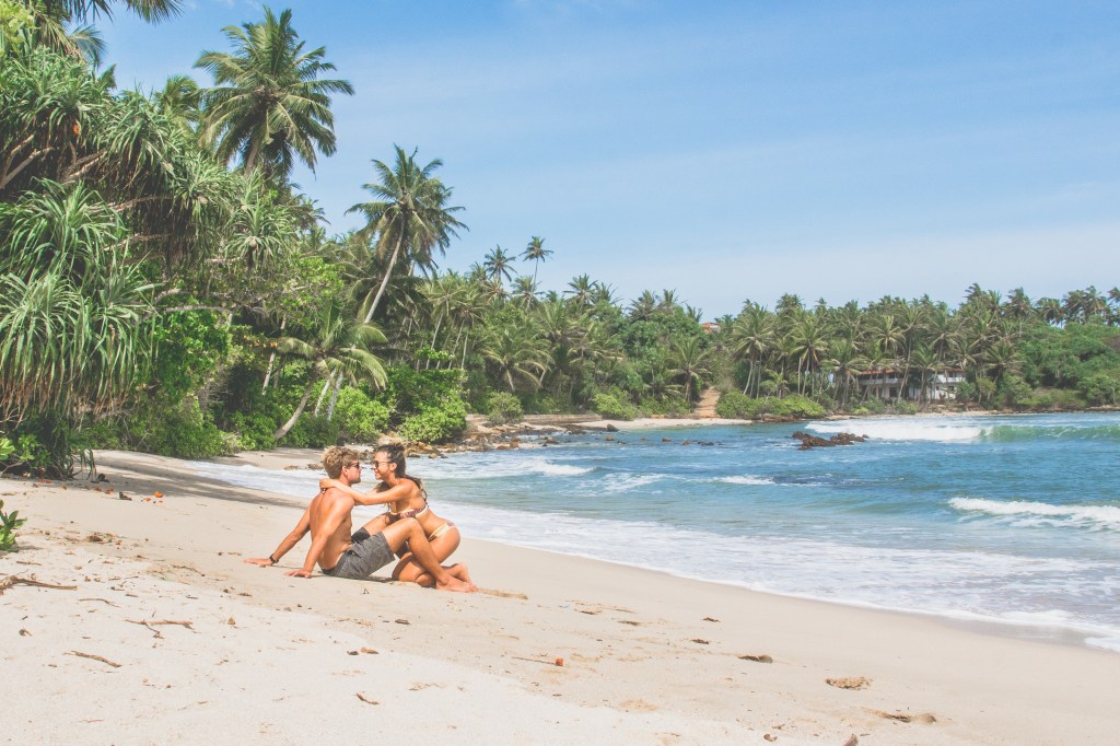 Image capturing Bianca and Brett enjoying the beautiful Hiriketiya Beach, a stunning coastal spot in Sri Lanka.