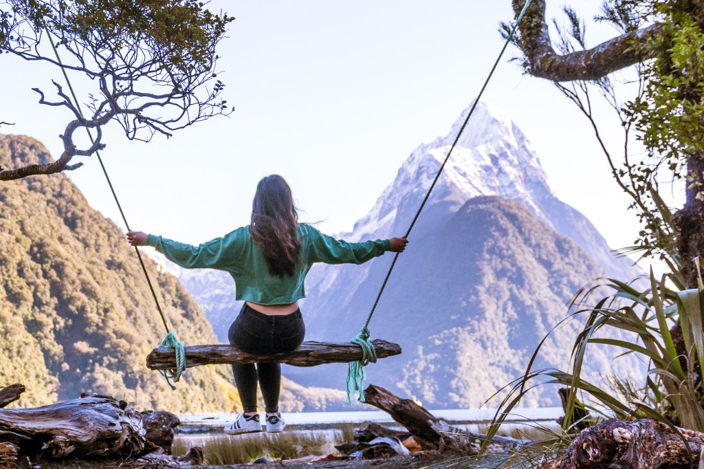 Joyful moment: Bianca swinging with the stunning backdrop of Milford Sound. A perfect blend of adventure and breathtaking landscapes at one of New Zealand's most iconic destinations.