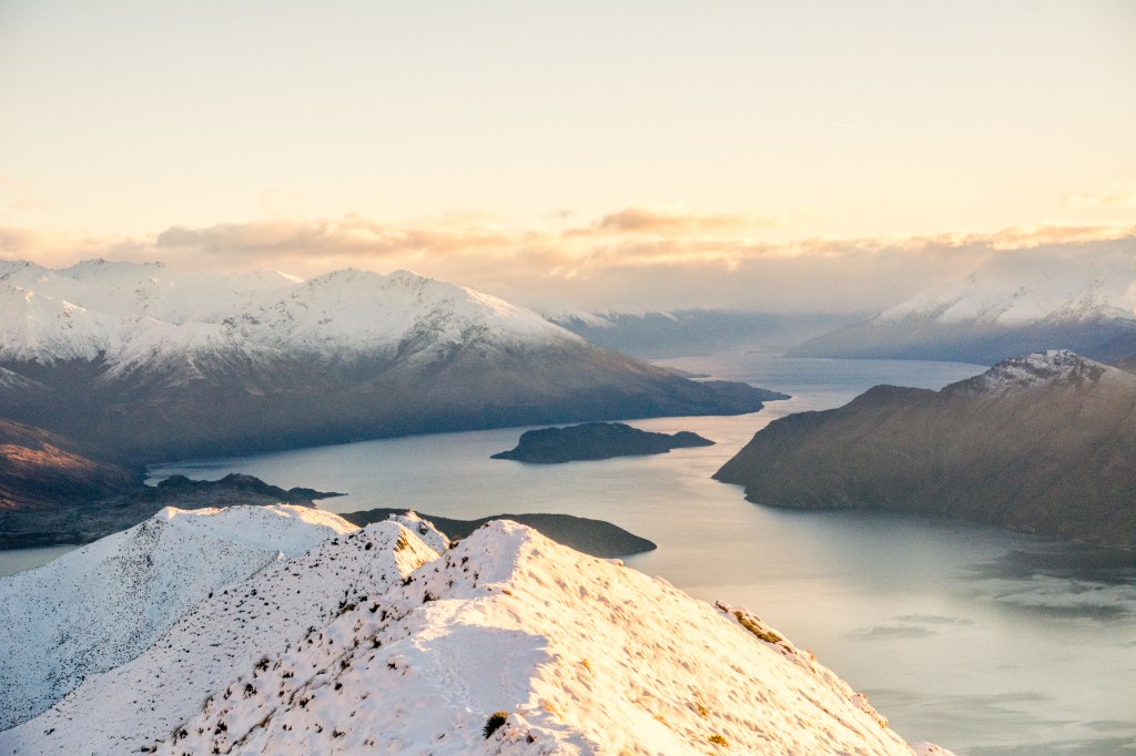 Enchanting sunrise view at Roys Peak, Wanaka - South Island. Immerse yourself in the magical hues as the sun paints the sky over this iconic New Zealand peak.