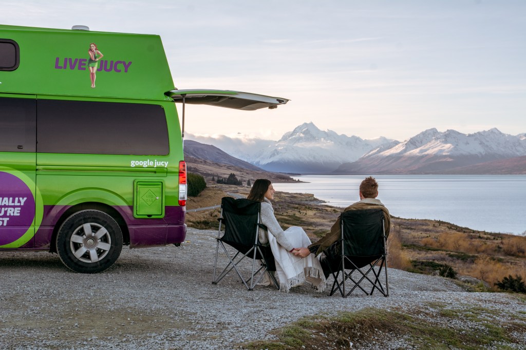 Bianca and Brett take a serene rest by the stunning Lake Pukaki. Immerse yourself in the tranquility of this pristine lakeside moment in New Zealand.