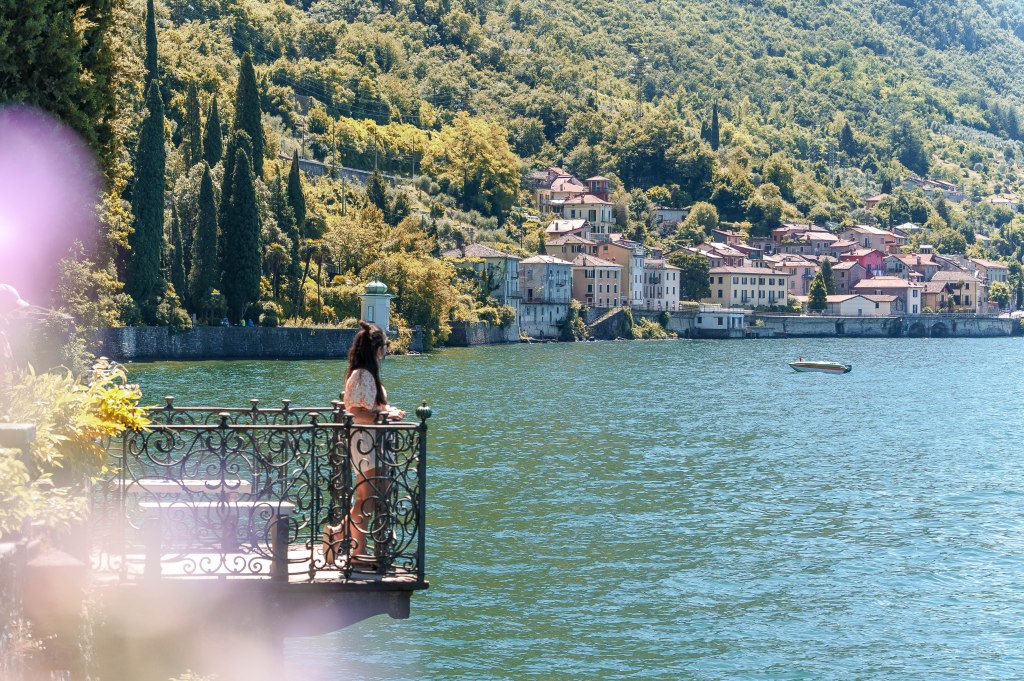 Image of Bianca admiring the beautiful gardens of Villa Monastero in Varenna, Lake Como, Italy, featuring lush greenery, vibrant flowers, and stunning lake views.