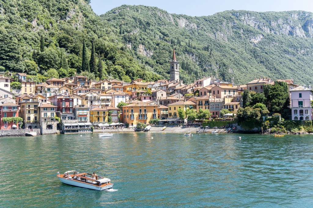 Aerial view captured by drone showing Brett and Bianca enjoying the serene beauty of Lake Como at dusk, with the sun setting behind the mountains.