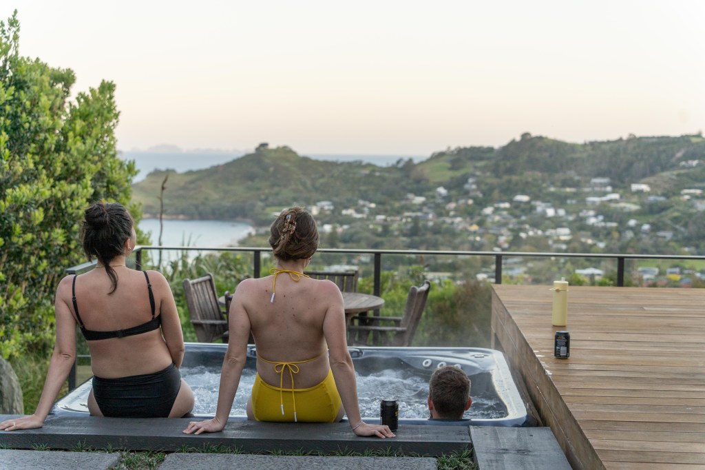 Enjoying the relaxing hot tub at Hahei Heights, a luxurious New Zealand accommodation with stunning views.