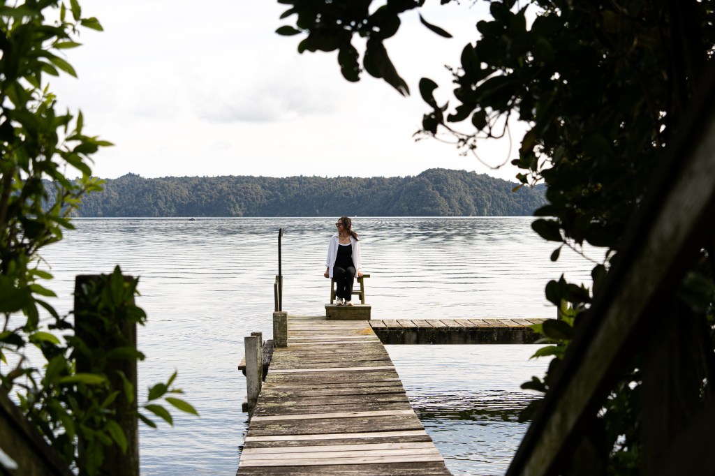 Peaceful moment on a quiet wharf overlooking Lake Rotoiti in Rotorua, New Zealand — hidden gem for serene lake views and nature lovers.