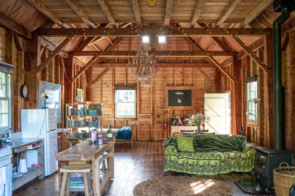 Rustic interior of the Wainui Seaside Glamping Barn featuring cozy decor, wooden accents, and coastal charm in New Zealand.