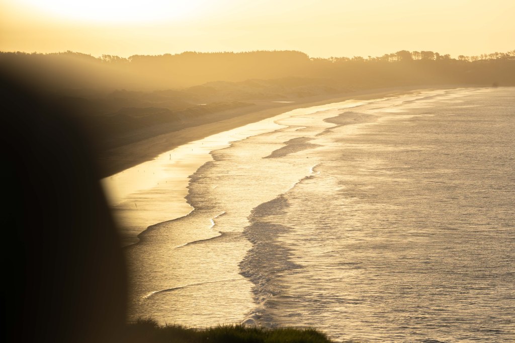 Stunning sunset at Puwheke Beach on the Karikari Peninsula, Northland New Zealand — vibrant evening sky reflecting over the ocean in the Far North.