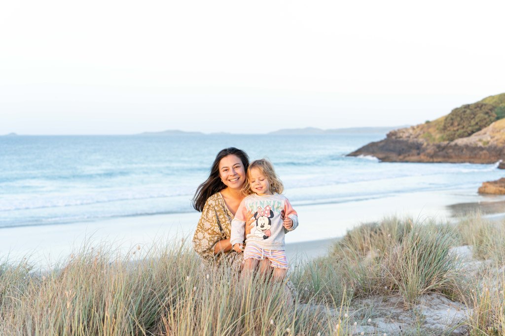 Bianca and her daughter Florence enjoying a golden sunset at Puwheke Beach on the Karikari Peninsula, Northland New Zealand — peaceful family beach moment in the Far North.