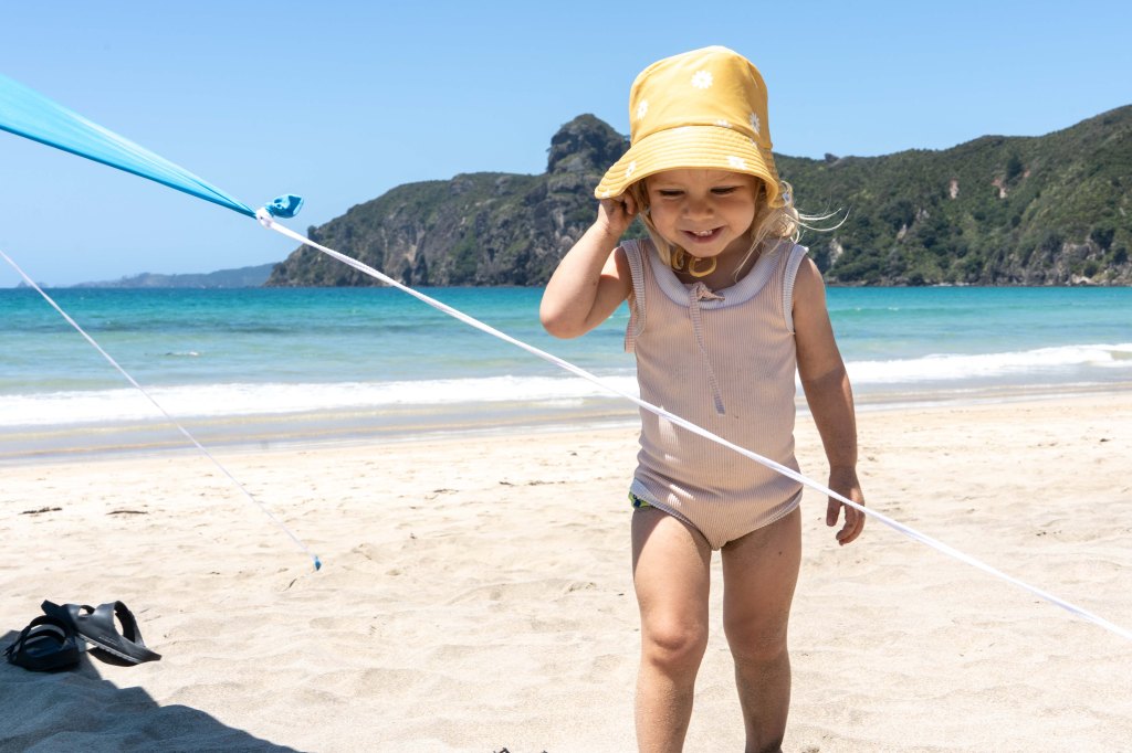 Florence playing and enjoying the sand at Taupo Bay, Northland New Zealand — family-friendly beach on the Far North coast with calm waves and golden sand.