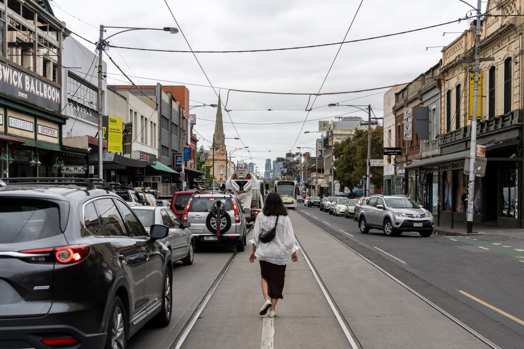 Bianca crossing a busy street in Brunswick, Melbourne, while exploring the city's vibrant inner-city neighbourhood.